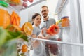 Happy couple near open fridge with vegetables and fruits. healthy nutrition concept Royalty Free Stock Photo