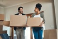 Happy couple or new home owners moving in together, carrying boxes of furniture or belongings and property. Loving Royalty Free Stock Photo