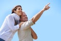 Happy, couple and outdoor pointing to sky, together with love and happiness on adventure in summer. Vacation, travel and Royalty Free Stock Photo