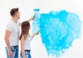 Happy couple painting walls in their new house ready for living together. Royalty Free Stock Photo