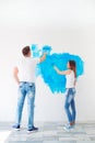 Happy couple painting walls in their new house ready for living together. Royalty Free Stock Photo