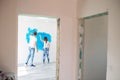 Happy couple painting walls in their new house ready for living together. Royalty Free Stock Photo