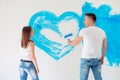 Happy couple painting walls in their new house ready for living together. Royalty Free Stock Photo