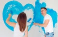 Happy couple painting walls in their new house ready for living together. Royalty Free Stock Photo