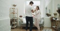 Happy couple in pajamas dacing in their cozy living room.