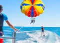 Happy couple Parasailing in Dominicana beach in summer. Couple u