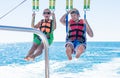 Happy couple Parasailing in Dominicana beach in summer. Couple under parachute hanging mid air. Having fun. Tropical Paradise. Pos Royalty Free Stock Photo