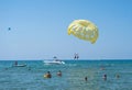 Happy couple Parasailing on Tropical Beach in summer. Couple under parachute hanging mid air. Having fun. Tropical Paradise. Posit