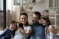 Happy couple of parents and laughing kids resting on couch Royalty Free Stock Photo
