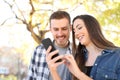 Happy couple in a park using a smart phone