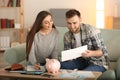 Happy couple with pay bills, calculator and money counting expenses indoors. Money savings concept Royalty Free Stock Photo