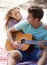 Happy couple, picnic and playing guitar for romance, love or music in outdoor bonding, fun or relaxing together in Royalty Free Stock Photo