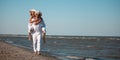Happy couple piggyback ride on sea shore Royalty Free Stock Photo
