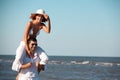 Happy couple piggyback ride on sea shore Royalty Free Stock Photo