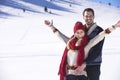 Happy couple playful together during winter holidays vacation outside in snow park Royalty Free Stock Photo