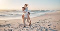 Happy couple playing on the beach. Carefree young couple having fun on holiday together. Husband giving his wife a Royalty Free Stock Photo
