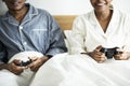 A happy couple playing video game in bed Royalty Free Stock Photo