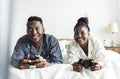 A happy couple playing video game in bed Royalty Free Stock Photo