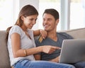 Happy couple, pointing and laptop with credit card for online shopping, payment or purchase on sofa at home. Man and Royalty Free Stock Photo