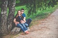 Pregnant woman and her husband on park bench