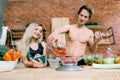 Happy couple preparing dinner in loft kitchen at home. Family cooking healthy food. The boy puts tomatoes on the weight Royalty Free Stock Photo