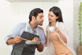 Happy couple preparing food at home, young couple cutting vegetables together at kitchen counter