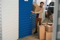 Young man and woman with big cardboard boxes in self storage unit Royalty Free Stock Photo