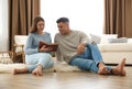 Happy couple reading book at home. Floor heating concept Royalty Free Stock Photo