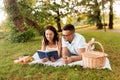 happy couple reading book on picnic at summer park Royalty Free Stock Photo