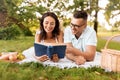 happy couple reading book on picnic at summer park Royalty Free Stock Photo