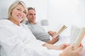 Happy couple reading books in bed Royalty Free Stock Photo