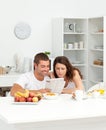 Happy couple reading the newspaper in the kitchen Royalty Free Stock Photo