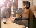 Happy couple, relax and talking with date at cafe for conversation or enjoying romance at indoor restaurant. Young man Royalty Free Stock Photo