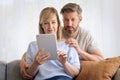 Woman and man sitting at home on the sofa and using touchpad Royalty Free Stock Photo