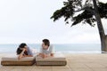 Happy Couple Relaxing On Sunbeds By Infinity Pool Royalty Free Stock Photo