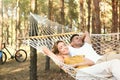 Happy couple resting in hammock outdoors on summer day