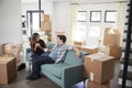 Happy Couple Resting On Sofa Surrounded By Boxes In New Home On Moving Day Royalty Free Stock Photo