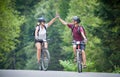 Happy couple ride on a mountain asphalt road on bikes