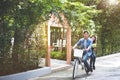 Happy couple riding bicycle together in romantic view park background. Valentine`s day and wedding honeymoon concept. People and Royalty Free Stock Photo