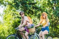 happy couple riding retro bicycles in park