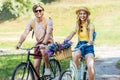 happy couple riding retro bicycles in park