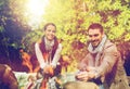 Happy couple roasting marshmallow over camp fire