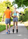 happy couple with roller skates riding outdoors Royalty Free Stock Photo