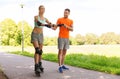 Happy couple with roller skates riding outdoors Royalty Free Stock Photo