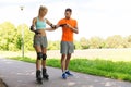 Happy couple with roller skates riding outdoors Royalty Free Stock Photo