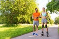 Happy couple with roller skates riding outdoors Royalty Free Stock Photo