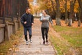 A happy couple runing in an autumn park. Outdoors. Royalty Free Stock Photo