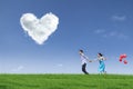 Happy couple running in field with balloons Royalty Free Stock Photo