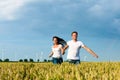 Happy couple running over grainfield Royalty Free Stock Photo