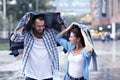 Happy couple running in the rain in the city Royalty Free Stock Photo